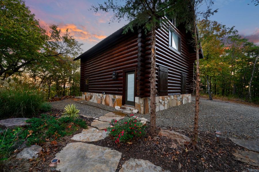 Guest cabin exterior with stone walkway at sunset