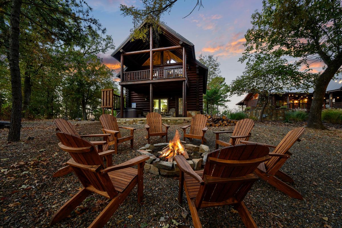 Fire pit ringed by Adirondack chairs beside the guest cabin