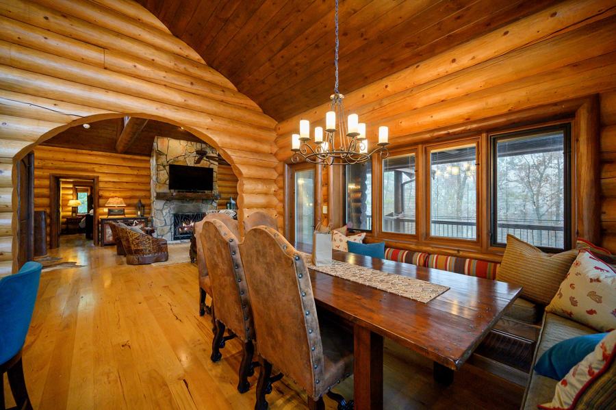 Dining table under a chandelier with views into the trees