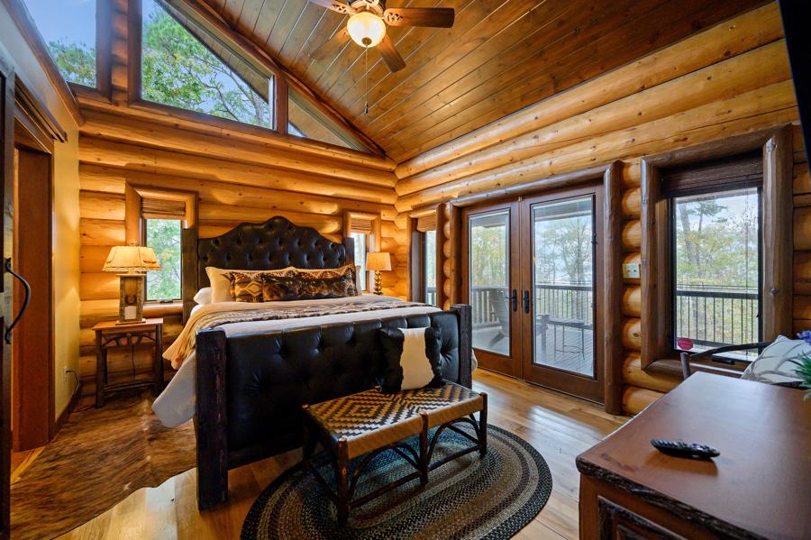 King suite with leather headboard and vaulted log ceiling